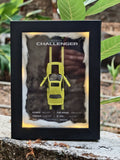Dodge Challenger neon yellow die-cast model in LED-lit black shadow box with road backdrop and performance specs